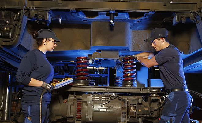 Zwei swa-Mitarbeiter stehen unter einem Auto in der Werkstatt