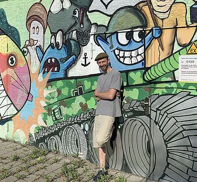 Header: Person vor Graffiti