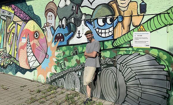 Header: Person vor Graffiti