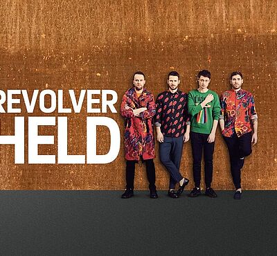 Vier Männer vor einem braunen Hintergrund. Rechts von ihnen steht der Schriftzug "Revolverheld"