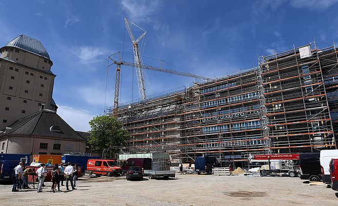 Baustelle des Parkhauses mit Gerüst und zwei Kränen im Hintergrund. Auf der linken Seite befindet sich das Ofenhaus Augsburg.