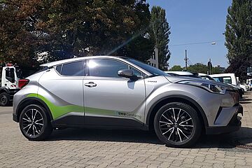 Seitenansicht eines Fahrzeuges der swa-Carsharing-Flotte, dem Toyota C-HR Hybrid, in den Farben Silber und Grün. - Ein Klick auf das Bild führt zur vergrößerten Fotoansicht.