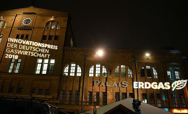 Ein Gebäude bei Nacht mit Projektionen der Aufschriften "Innovationspreis der deutschen Gaswirtschaft 2018" und "Erdgas".