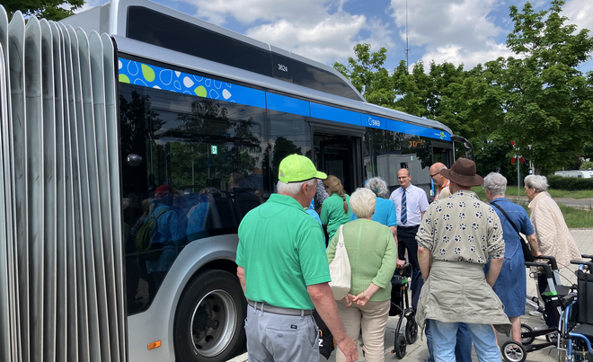 Seniorinnen und Senioren stehen vor einem Bus der swa.