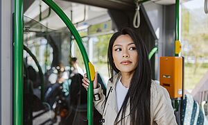 Frau steht in einer Straßenbahn an einer Tür. Mit Weiterverlinkung zu Firmen-Abo / Firmen-Abo Premium
