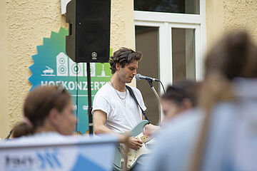 Mann vor einem Gebäude am singen. - Beim anklicken wird das Bild vergrößert.