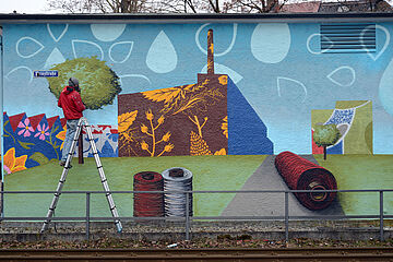 Eine Leiter steht vor einer bemalten Wand. - Ein Klick auf das Bild führt zur vergrößerten Fotoansicht.