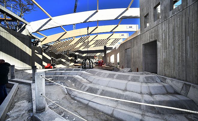 Baustelle des neuen Elefantenhauses mit Felsvorsprüngen im Vordergrund. Ein Kran legt Dekorierung ab. Im Hintergrund befinden sich weitere Geräte zur Durchführung der Bauarbeiten.