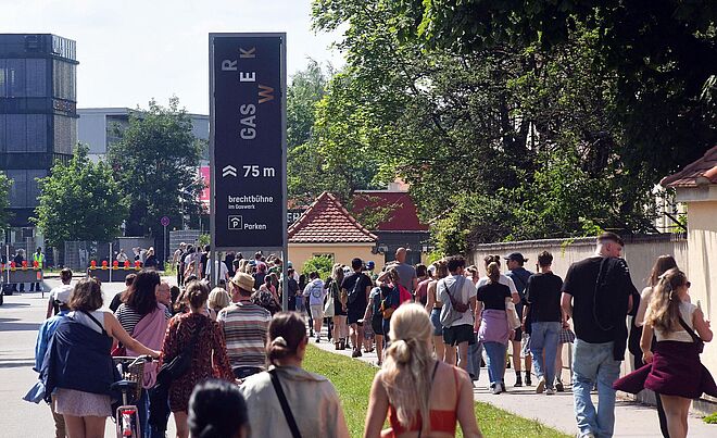 Leute laufen in einer Schlange auf das Gaswerksgelände. Weiterverlinkung auf Summerstage Gaswerk Newsartikel