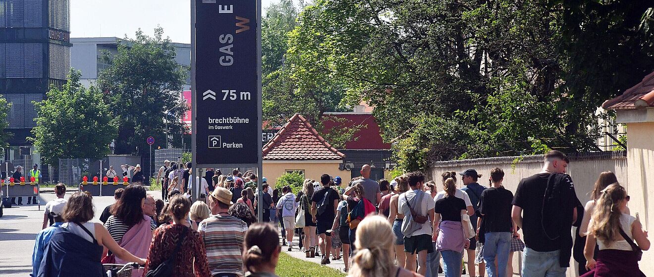 Leute laufen in einer Schlange auf das Gaswerksgelände. Weiterverlinkung auf Summerstage Gaswerk Newsartikel