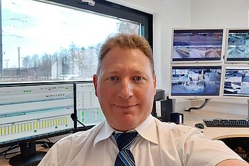 Ein Selfie von einem Mann, der vor mehreren Monitoren sitzt. - Ein Klick auf das Bild führt zur vergrößerten Fotoansicht.