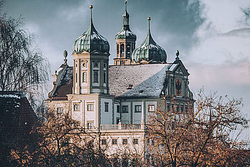 Augsburger Rathaus mit Schnee bedeckt. Im Vordergrund befinden sich Bäume. - Ein Klick auf das Bild führt zur vergrößerten Fotoansicht.