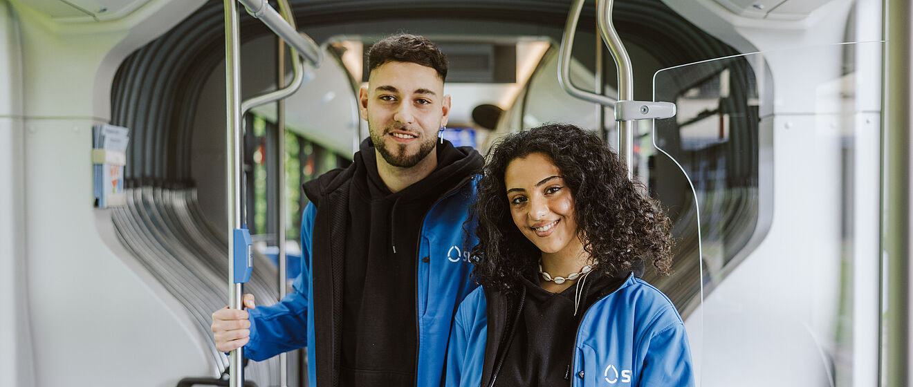 Zwei Mitarbeiter im Prüfdienst mit swa Jacke stehen in einer Straßenbahn