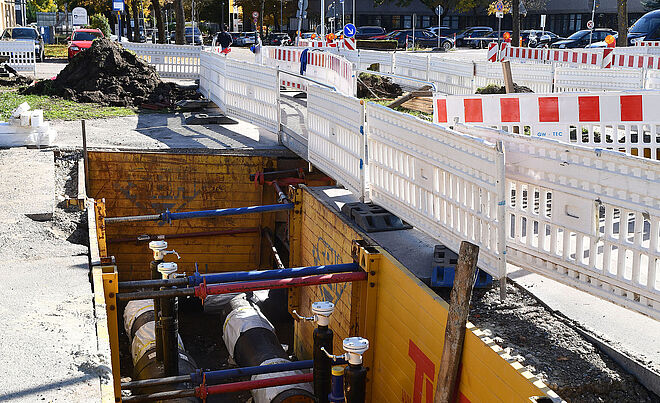 Eine Baustelle in der Nähe des KUKA-Hauptquartiers in Augsburg zeigt Tiefbauarbeiten für eine neue Fernwärmeleitung der Stadtwerke Augsburg (swa).