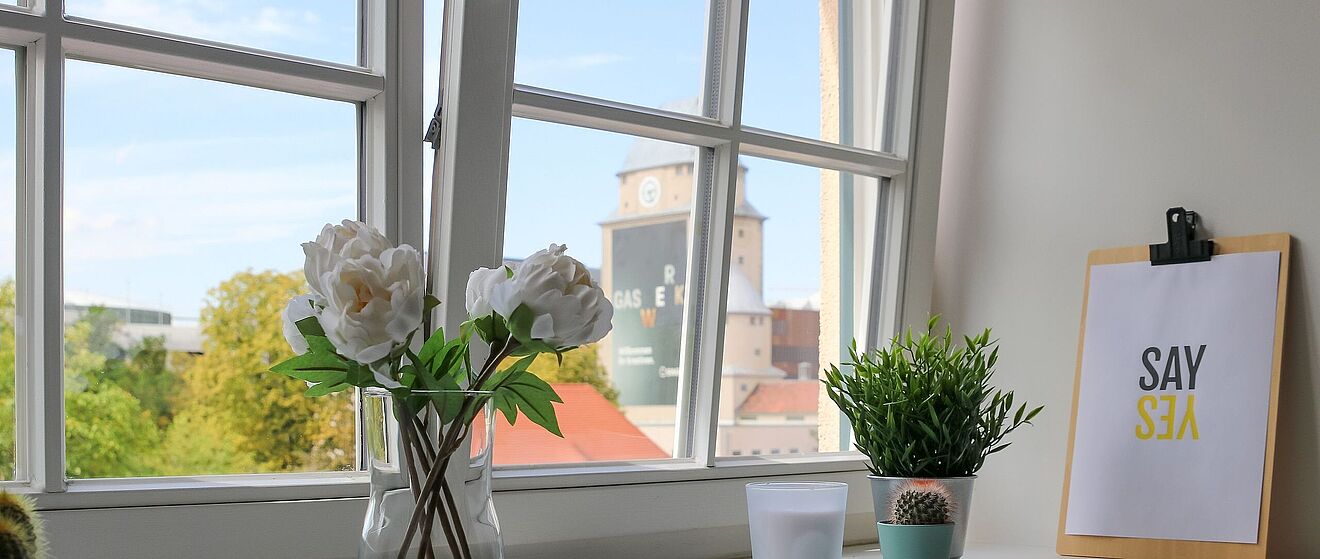 Blumen in Vasen auf einem Fensterbrett. Weiterverlinkung auf Gaswerk neue Räume Newsartikel