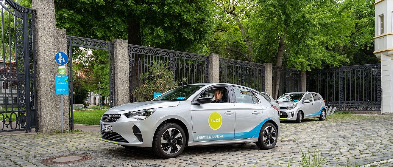 Mann sitzt in einem stehenden swaxi vor einem Tor und schaut aus dem Fenster.