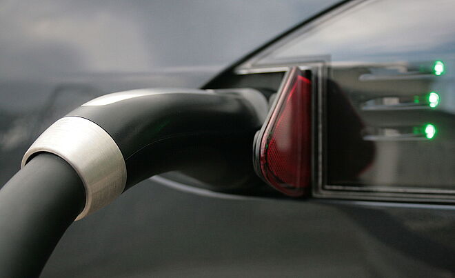 Ausschnitt eines Tankdeckels, der mit einem e-Ladeschlauch verbunden ist. Weiterverlinkung auf swa Emobilitäts-Seite