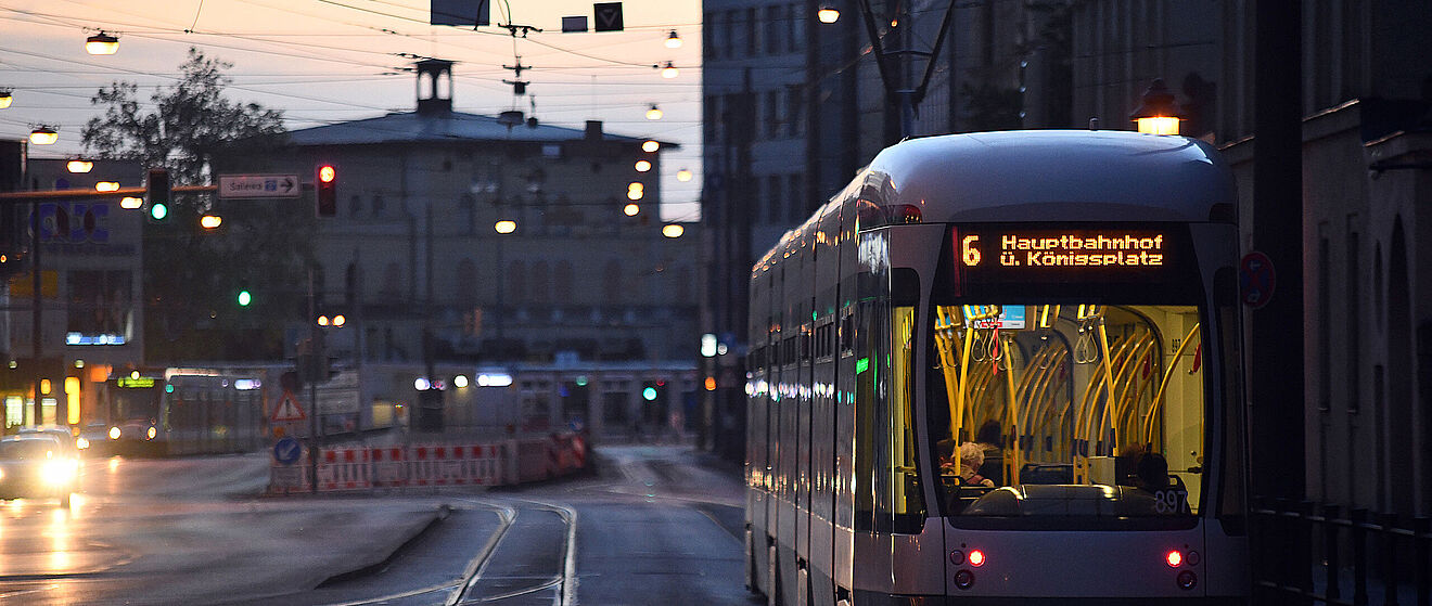 Straßenbahn fährt bei Dämmerung richtung Hauptbahnhof