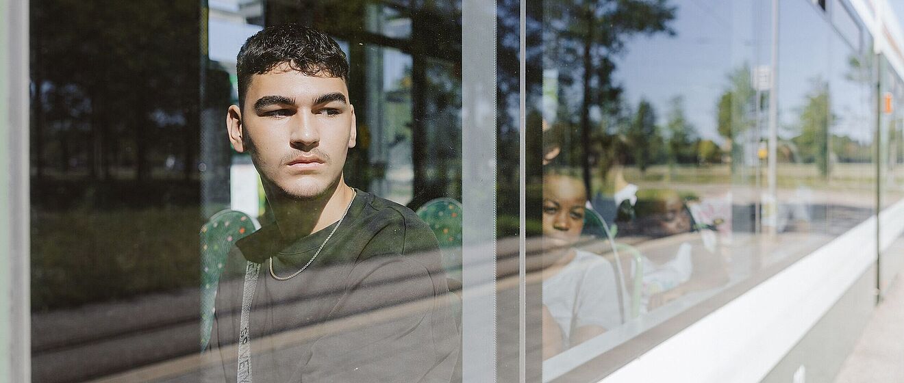 Schüler sitzen in einer Straßenbahn und schauen aus dem Fenster