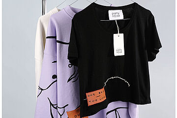 Oberteile die an einer Stange hängen. - Beim anklicken wird das Bild vergrößert.