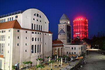 Modell des Gaswerksgelände mit rot leuchtenden Gaskessel im Hintergrund. - Ein Klick auf das Bild führt zur vergrößerten Fotoansicht.