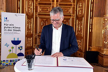 Politiker unterschreibt Klimapakt im Augsburger Rathaus - Ein Klick auf das Bild führt zur vergrößerten Fotoansicht.