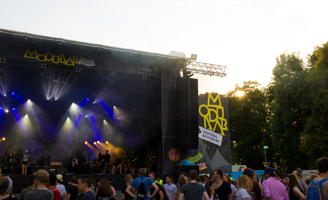Eine Bühne mit Live-Musik auf dem Augsburger Modular-Festival im Wittelsbacher Park. Davor befindet sich eine Zuschauermenge.