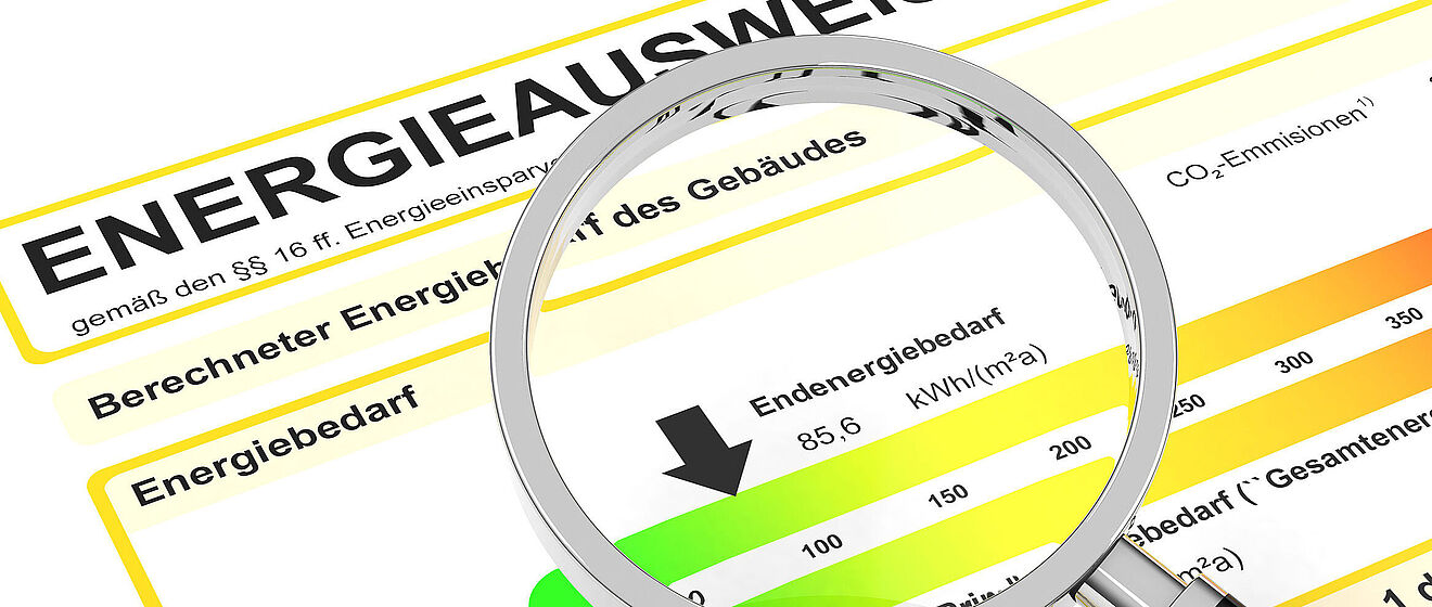 Der Energieverbrauch unter der Lupe Ausschnitt eines Energieausweises für Wohnungen mit einer Lupe im Vordergrund