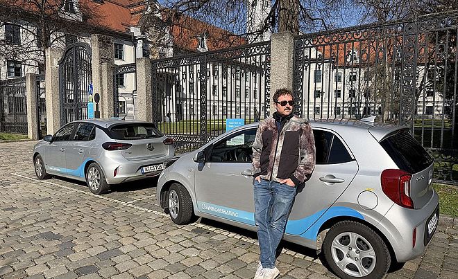 Ein Mann steht vor zwei swa Carsharing-Autos