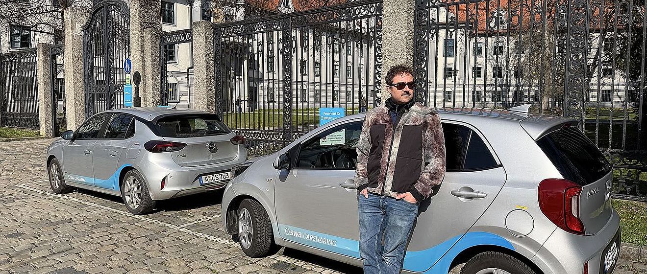 Ein Mann steht vor zwei swa Carsharing-Autos
