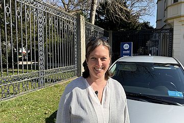 Eine Frau steht vor einem swa Carsharing-Auto