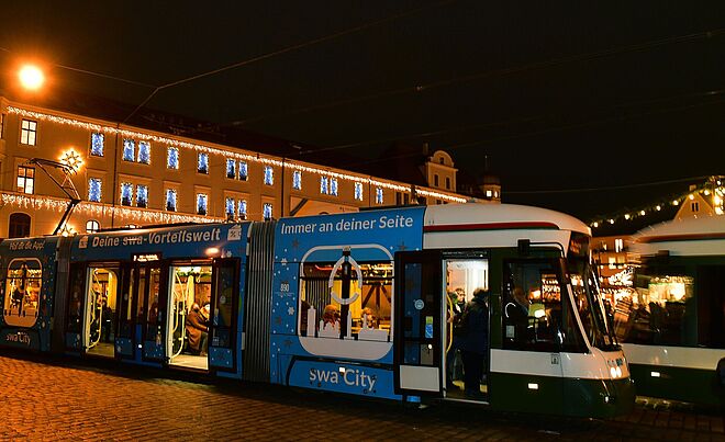 Foto der swa Christkindltram auf dem weihnachtlichen Rathausplatz.