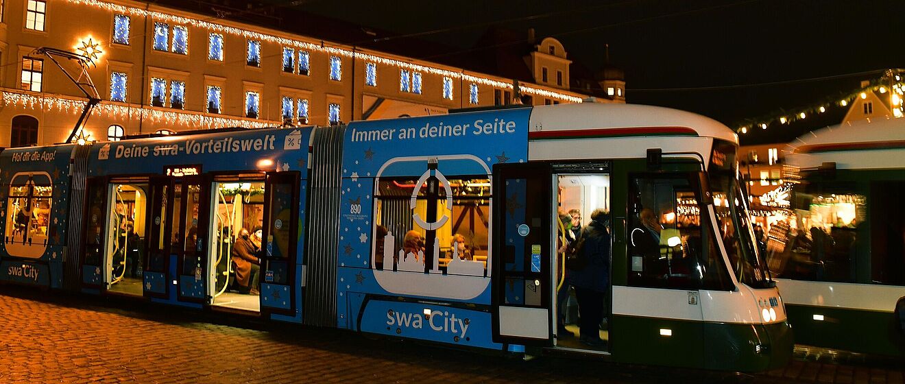 Foto der swa Christkindltram auf dem weihnachtlichen Rathausplatz.