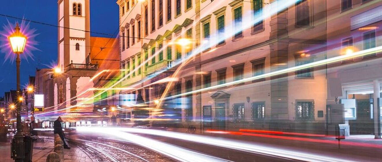 Augsburg Maxstraße mit Perlachturm im Hintergrund und Lichteffekten