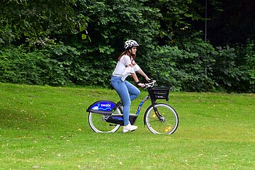 Frau im Grünen auf Fahrrad