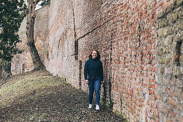 Eine junge Dame spaziert an der Stadtmauer am Fischertor. - Ein Klick auf das Bild führt zur vergrößerten Fotoansicht.