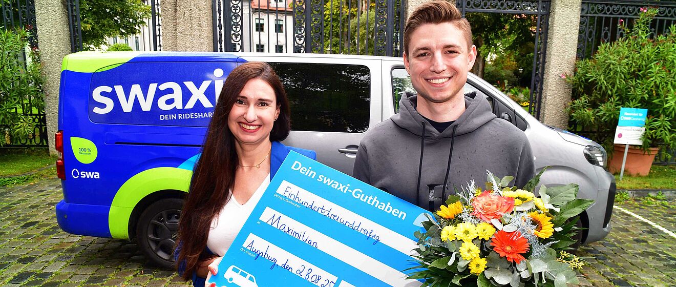 swa Projektleiterin Julia Boxler überreicht dem 33.333 swaxi Kunden Maximilian Fahrtguthaben.
