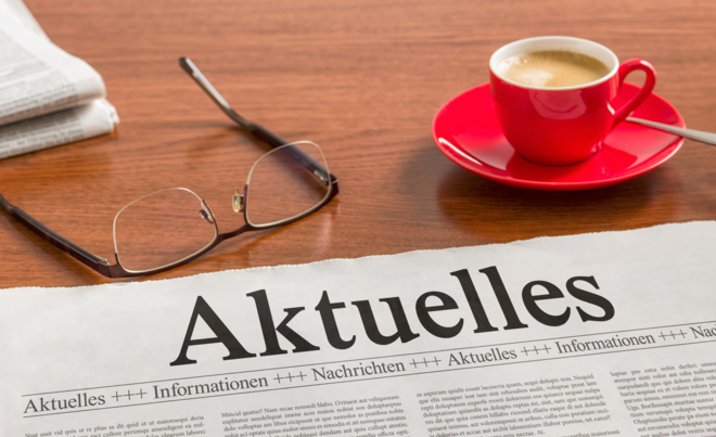 Tisch auf dem eine Zeitung eine Brille und eine Kaffeetasse liegt. Weiterverlinkung zu swa Presse