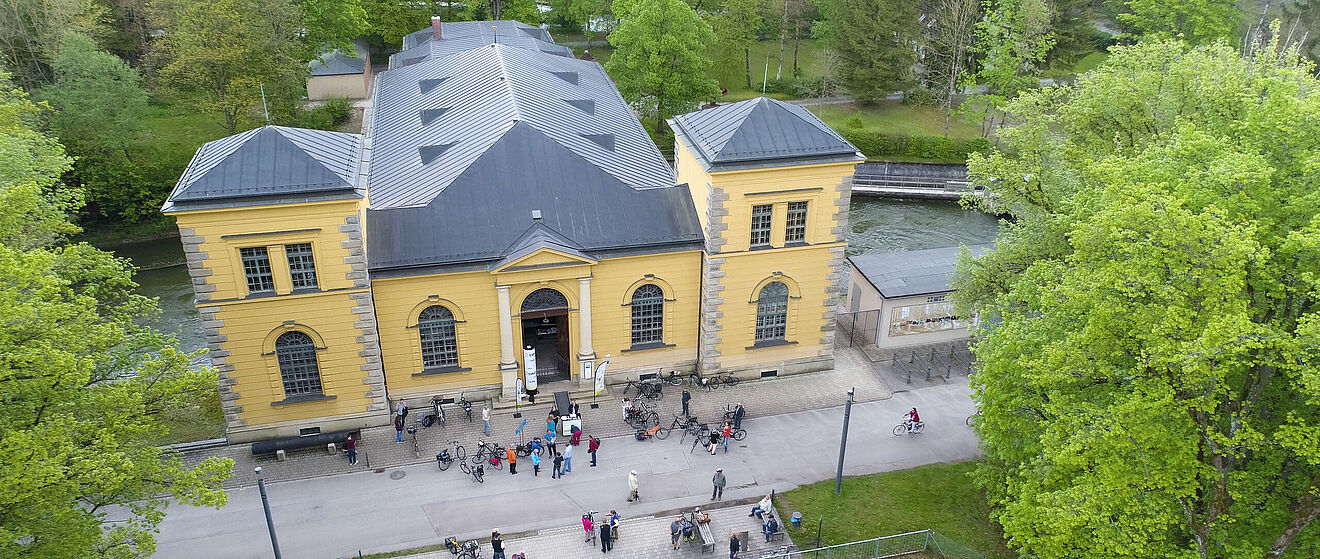 Das Wasserwerk am Hochablass mit vielen Menschen mit Fahrrädern umgeben.