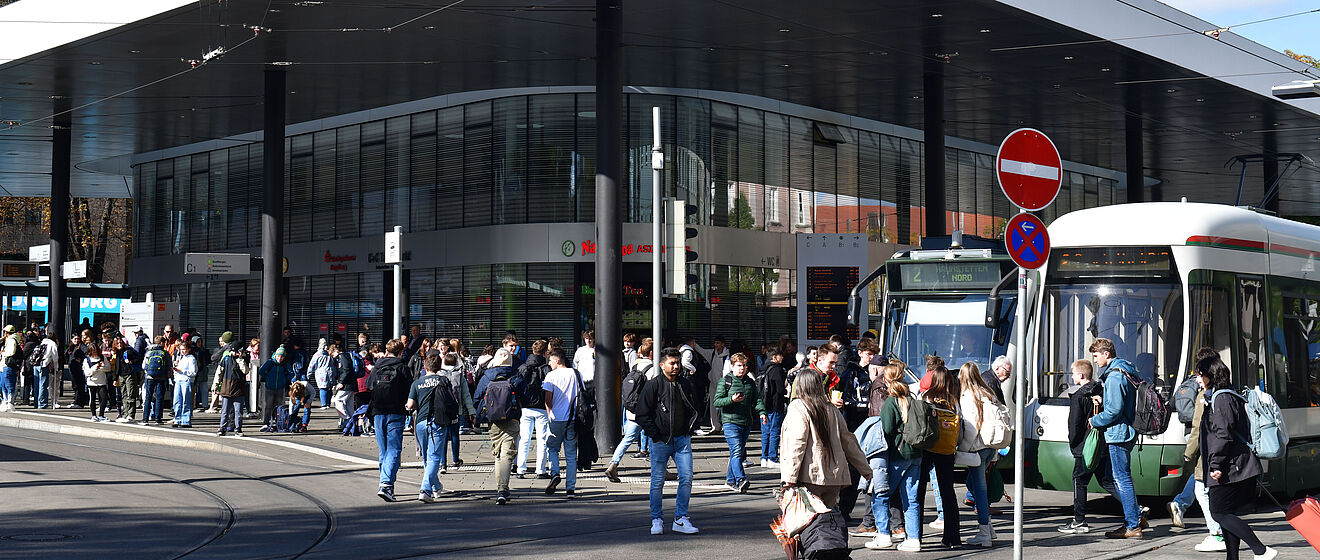 Menschenmenge läuft an der Haltestelle Königsplatz. Es stehen einige Straßenbahnen an den Stationen