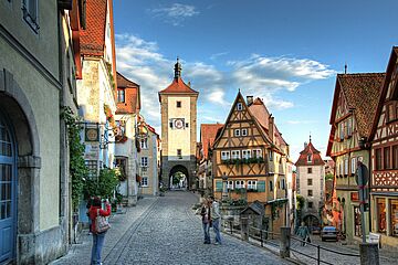 Zwei Personen werden von einer Frau in der Altstadt von Rothenburg ob der Tauber fotografiert. Ein Klick sorgt für eine Großansicht des Bildes.