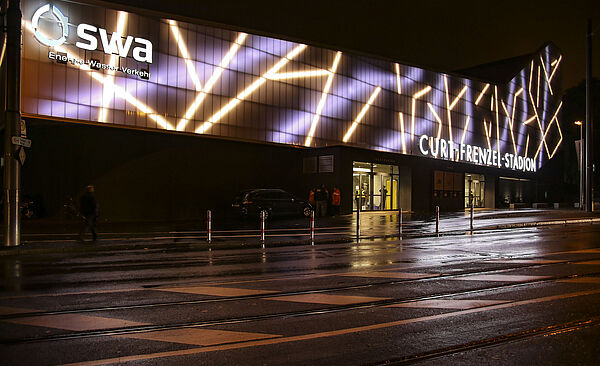 Curt-Frenzel-Stadion bei nacht mit swa Logo. Weiterverlinkung auf swa Innovation und Zukunftsseite