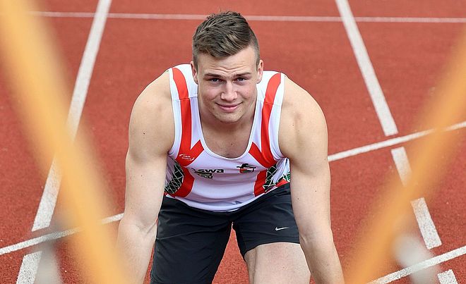 Aleksandar Askovic (swa Sportler) befindet sich in der Startposition zum Sprint und blickt in die Kamera.