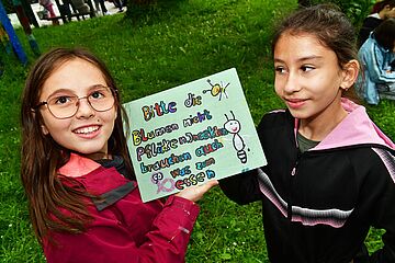 Zwei Kinder halten ein selbstgemaltes Plakat in die Höhe - ein Klick darauf führt zur Fotoansicht