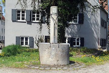 Trinkwasserbrunnen in der Schwibbogengasse im Hintergrund ist eine Wiese und ein Wohngebäude